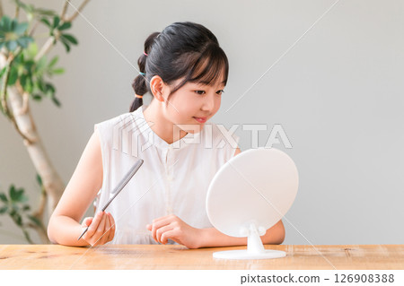 兒童、女孩、小學生和國中生對著鏡子做頭髮 兒童、女孩、小學生和國中生對著鏡子做頭髮 126908388