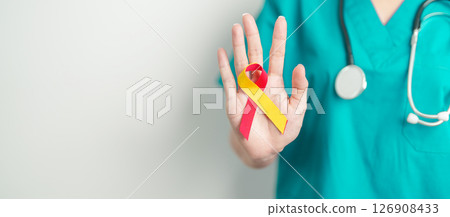 World hepatitis day awareness month, 28 July. Doctor holding Red and Yellow ribbon. Liver cancer, Jaundice, Cirrhosis, Failure, Enlarged, Hepatic Encephalopathy and Health concept 126908433