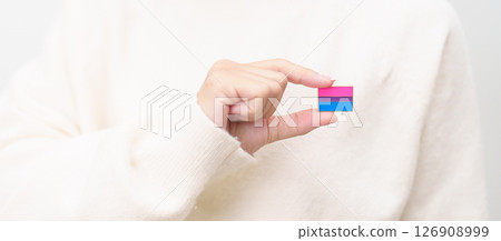 Bisexuality Celebrate Day and LGBT pride month, LGBTQ or LGBTQIA concept. Hand holding purple, pink and blue flag shape for Lesbian, Gay, Bisexual, Transgender, Queer, Pansexual, Marriage Equality Law 126908999