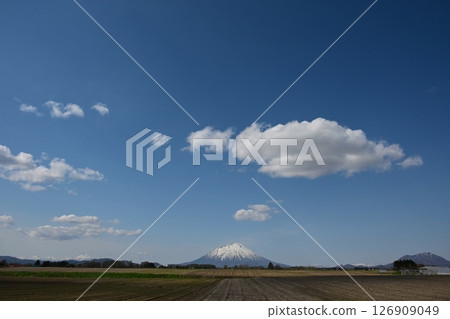 White clouds floating in the spring blue sky and Mt. Yotei, Niseko mountain range and Mt. Shiribetsu White clouds floating in the spring blue sky and Mt. Yotei, Niseko mountain range and Mt. Shiribetsu 126909049