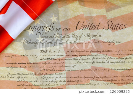 Historic Congress parchment document displayed against backdrop of American flag, showcasing date significance. 126909235