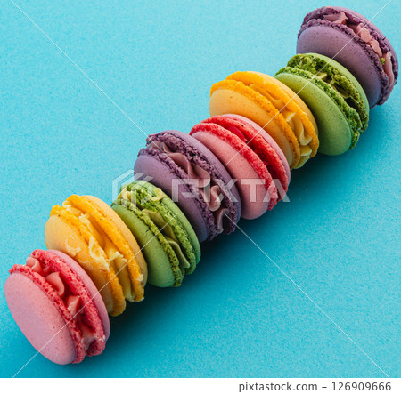 Colorful macaron display on a blue background Colorful macaron display on a blue background 126909666