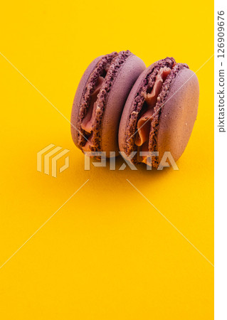Chocolate macarons on a vibrant yellow background Chocolate macarons on a vibrant yellow background 126909676