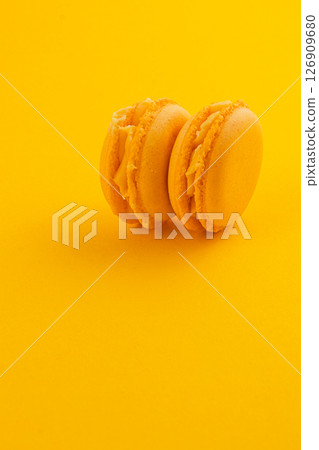 Delightful yellow macarons on vibrant background 126909680