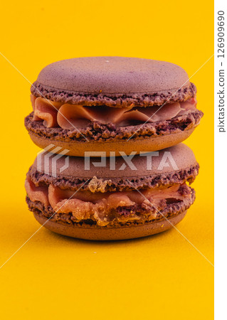 Choco caramel macarons on a vibrant yellow background 126909690