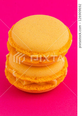 Delicious yellow macarons on a vibrant pink background 126909692
