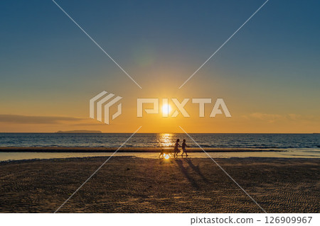 Silhouette of a child walking on the beach 126909967