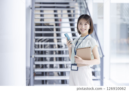 Business portrait of a young woman holding a smartphone Business portrait of a young woman holding a smartphone 126910062