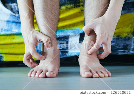 Men wear canvas shoes, he scratches legs and feet with itchy skin. Caused by  of shoes 126910631