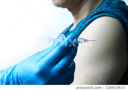 doctor's hand holds a syringe and a blue vaccine bottle at the hospital. Health and medical concepts. 126910633