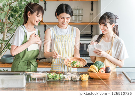A female instructor and female students teaching cooking at a cooking class/cooking school 126910726
