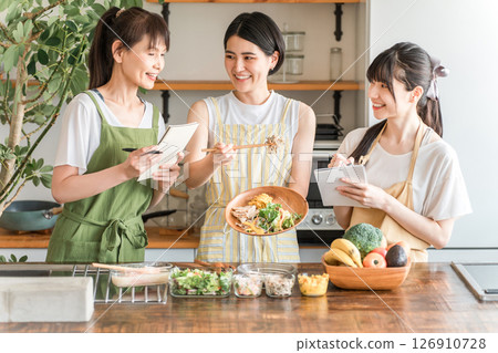 A female instructor and female students teaching cooking at a cooking class/cooking school A female instructor and female students teaching cooking at a cooking class/cooking school 126910728