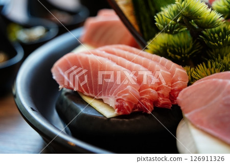 Close-up of Sliced Tuna Sashimi on Black Plate 126911326