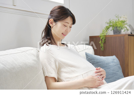 坐沙發和接觸她的胃的孕婦 126911424