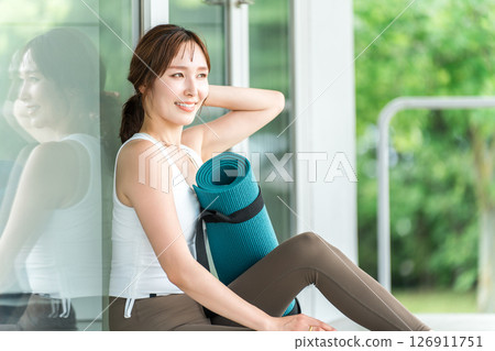 A woman who is a yoga instructor with a yoga mat, a woman who does yoga and Pilates A woman who is a yoga instructor with a yoga mat, a woman who does yoga and Pilates 126911751