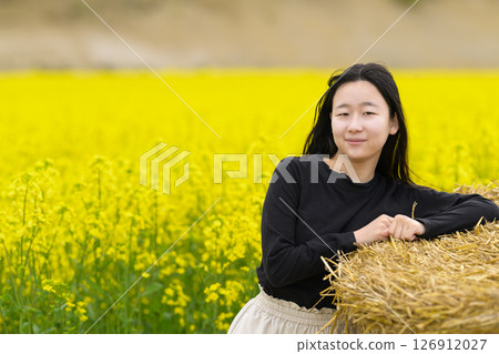 一名女子在盛開的油菜花田中觀光 一名女子在盛開的油菜花田中觀光 126912027
