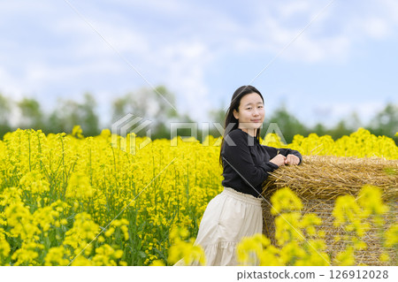 一名女子在盛開的油菜花田中觀光 一名女子在盛開的油菜花田中觀光 126912028