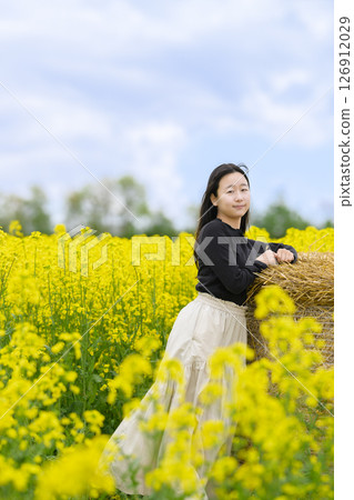 A woman sightseeing in a field of rapeseed flowers in full bloom 126912029