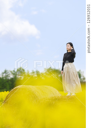 一名女子在盛開的油菜花田中觀光 126912031
