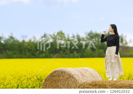 一名女子在盛開的油菜花田中觀光 126912032