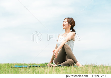 草原上冥想、瑜珈、伸展運動、皮拉提斯的女人（保健/飲食） 126912519