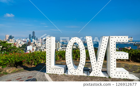 White LOVE marquee letters crown Love Lookout on Shoushan hill, facing the high-rise skyline and harbor of Kaohsiung, Taiwan, under a vivid blue summer sky. White LOVE marquee letters crown Love Lookout on Shoushan hill, facing the high-rise skyline and harbor of Kaohsiung, Taiwan, under a vivid blue summer sky. 126912677