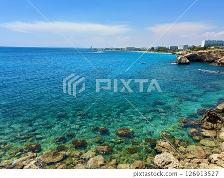 Picturesque beach, waves crashing on the sandy shore. Sea waves beat against the rocks. Cyprus Island, Mediterranean Sea. 126913527