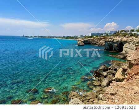 Picturesque beach, waves crashing on the sandy shore. Sea waves beat against the rocks. Cyprus Island, Mediterranean Sea. 126913528