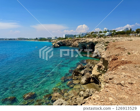 Picturesque beach, waves crashing on the sandy shore. Sea waves beat against the rocks. Cyprus Island, Mediterranean Sea. 126913529