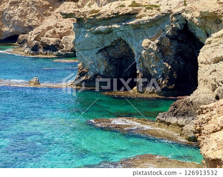 Picturesque beach, waves crashing on the sandy shore. Sea waves beat against the rocks. Cyprus Island, Mediterranean Sea. 126913532
