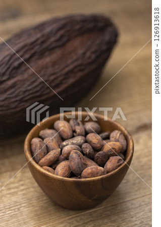 Cocoa pods and roasted cocoa beans on a wooden table 126913618