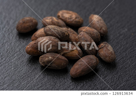 Roasted cocoa beans arranged on a black slate 126913634