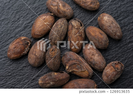 Roasted cocoa beans arranged on a black slate 126913635