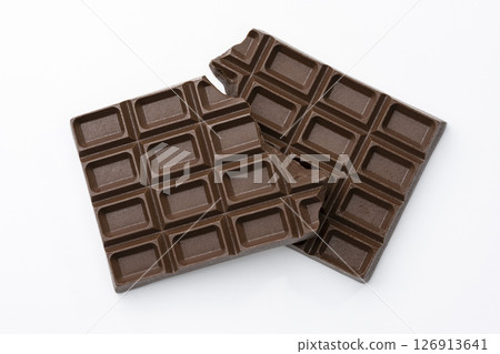 Aerial view of broken chocolate bars arranged on a white background 126913641