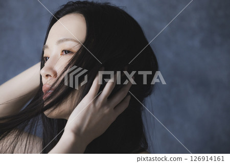 A woman wearing a black off-the-shoulder 126914161