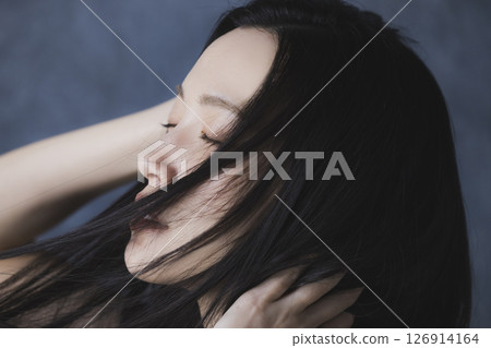 A woman wearing a black off-the-shoulder 126914164