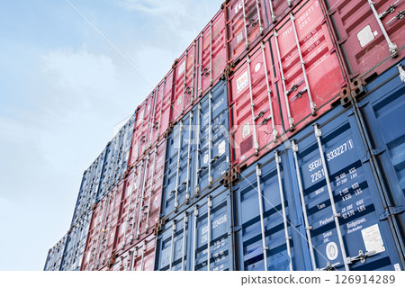 Shipping containers of various colors stacked in a container yard 126914289