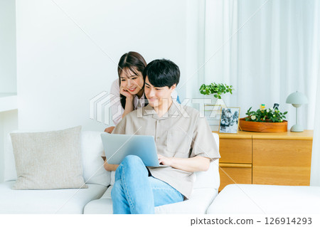 一對夫婦在客廳裡看電腦 126914293