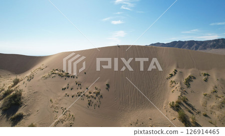 Hikers walking on the crest of a sand dune in the desert Hikers walking on the crest of a sand dune in the desert 126914465