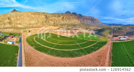 Aerial Lush Circular Farmland Red Rock Desert and Rural Road Panorama Fly Through 126914562