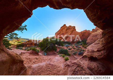 Red Sandstone Formations and Desert Shrubs Framed by Cave Arch Motion Perspective Red Sandstone Formations and Desert Shrubs Framed by Cave Arch Motion Perspective 126914564