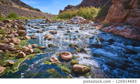 Aerial Motion Over Virgin River Flowing Through Rugged Desert Canyon 126914693