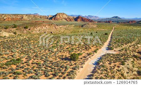 Aerial Fly Over Desert Road and Red Rock Mesas with Sagebrush Patterns Aerial Fly Over Desert Road and Red Rock Mesas with Sagebrush Patterns 126914765