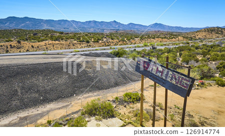 Aerial Weathered Roadside Sign Abandoned Highway Desert Landscape Fly Through 126914774