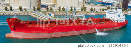 Red chemical tanker moored at industrial port terminal, side view Red chemical tanker moored at industrial port terminal, side view 126914864