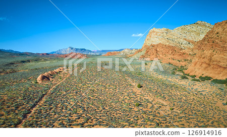 Aerial Fly Through Red Sandstone Cliffs Desert Plains and Distant Mountains 126914916