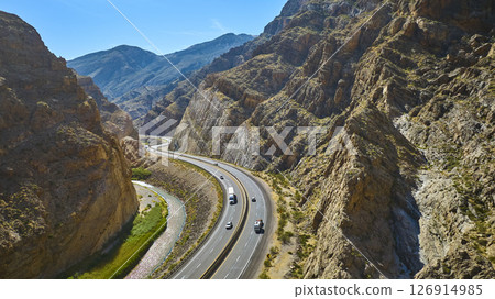 Aerial Motion Over Desert Canyon Highway River and Rugged Rock Walls 126914985