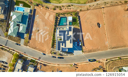 Aerial Modern Home With Solar Panels and Pool in Developing Suburb Fly Over 126915054