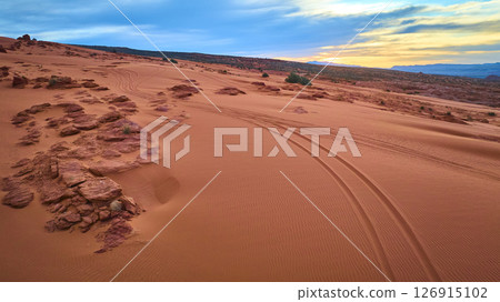 Aerial Tire Tracks on Red Sand Dunes and Rock Formations at Sunrise in Utah Aerial Tire Tracks on Red Sand Dunes and Rock Formations at Sunrise in Utah 126915102