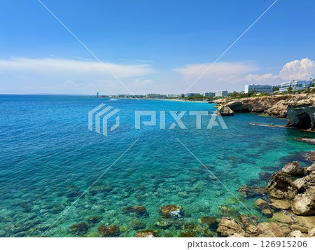 Picturesque beach, waves crashing on the sandy shore. Sea waves beat against the rocks. Cyprus Island, Mediterranean Sea. 126915206